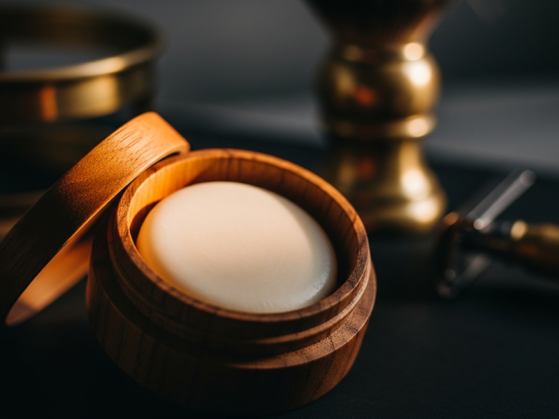 An open artisan shaving soap tub showing a smooth cream puck