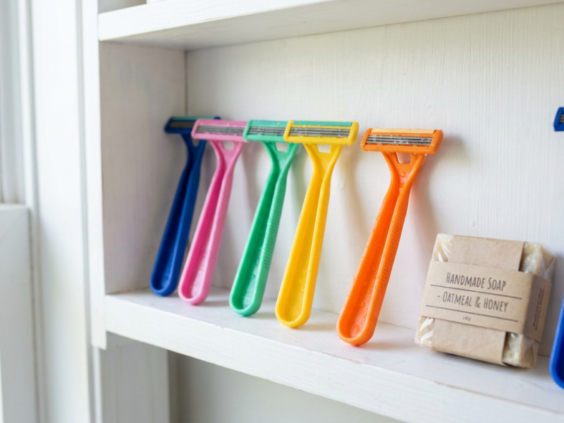 Disposable razors with two, three and five blade heads lined up beside a bar of soap